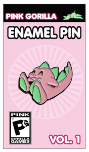 An enamel pin with our former mascot character, a pink and green dinosaur. The pin is on a light pink pin backing, which says Pink Gorilla Enamel Pin, Vol. 1
