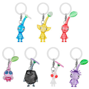 Seven Pikmin keychains. Blue, Yellow, Red, Pink, Black (Rock), White, and Purple.