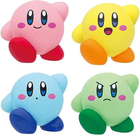 Small vinyl kirby figures. Top left is pink and smiling. Top right is yellow and smiling with an open mouth. Bottom left is blue with a dot for a mouth. Bottom right is green and angry.