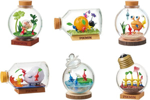 Pikmin Terrariums: a bottle featuring Olimar plucking a red pikmin amongst some clovers. A bottle on its side featuring several pikmin carrying an orange. A bottle featuring a bulborb eating a blue pikmin while other pikmin attack. A bottle featuring a Blowhog both attacking and being attacked by pikmin. A bottle featuring two blue pikmin in the water while a red pikmin watches from the grass. A lightbulb shaped bottle featuring three yellow pikmin amongst some red mushrooms.