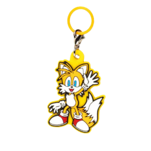 Keychain of tails from the sonic the hedgehog series. He is holding one hand up to wave and is outlined with yellow rubber.