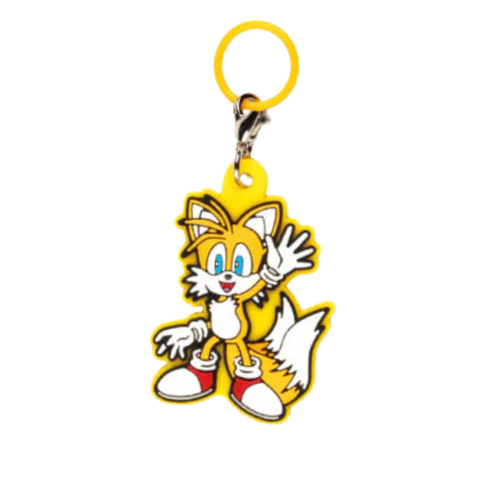 Keychain of tails from the sonic the hedgehog series. He is holding one hand up to wave and is outlined with yellow rubber.