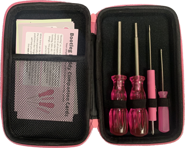 An image showing the inside of the bootleg buddy. It is a black case with pink zippers. On the left you can see the bootleg buddy companion cards, which give information on spotting bootleg games. On the right are the four screwdrivers included in the set. All four screwdrivers are pink.